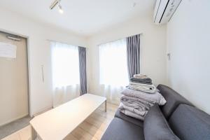 a living room with a couch and some windows at 12 とりっぱーずホテル高田馬場 in Tokyo