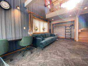 Una sala de estar con un sofá y un reloj en la pared. en Five room 120 SKY TREE SENSOJI FreeParking 1292sqft, en Tokio