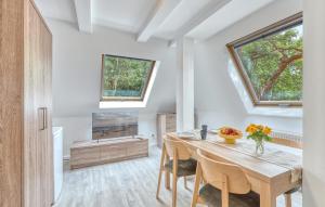 a dining room with a wooden table and two windows at Gorgeous Apartment In Altenkirchen With Wifi in Altenkirchen