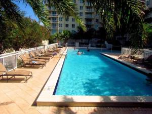 a swimming pool with lounge chairs and a building at One Bedroom In Amazing Condobeach Pass Included! in Boynton Beach