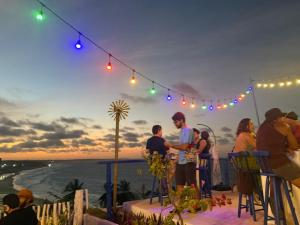 a group of people standing at a bar with a view of the ocean at Grace Palace in Tigre