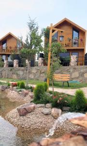 a house with a bench in front of a river at أكواخ الصنوبر in Suda