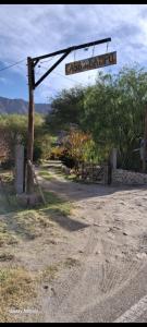 a street sign on a pole on a dirt road at Della monica in Tinogasta