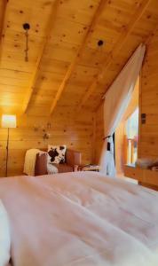a bedroom with a white bed and a couch at أكواخ الصنوبر in Sawdāʼ