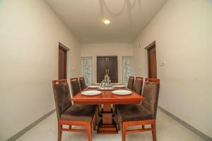 a dining room with a wooden table and chairs at Heavenly Hills 4 BHK Villa - 1 Bedroom in Kotagiri +9 photos