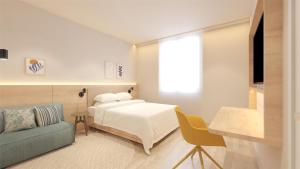 a bedroom with a bed and a couch and a tv at Hampton By Hilton Caraguatatuba Serramar in Caraguatatuba