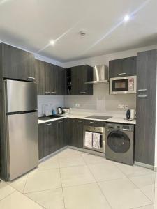 a kitchen with wooden cabinets and a stainless steel appliance at Loxwood House Luxury Apartment in Accra
