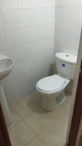 Un baño blanco con inodoro y lavabo. en Casita entre árboles, casa de huéspedes céntrica y cómoda en San Fernando, Cali, en Cali