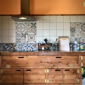 a kitchen with a wooden counter top and tiles at Casa Malagueta in Lajes das Flores +19 photos