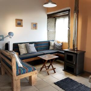 a living room with a blue couch and a stove at Casa Malagueta in Lajes das Flores
