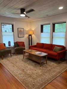 a living room with a red couch and a coffee table at Historic bungalow on Church Street in Georgetown