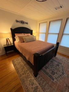 a bedroom with a large bed in a room with windows at Historic bungalow on Church Street in Georgetown