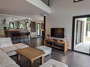 a living room with a couch and a tv at Maison avec jardin clos et piscine privée - FR-1-653-279 in Soyaux