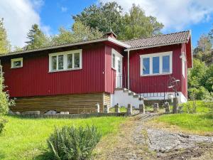 a red and white house in a field at 4 person holiday home in UDDEVALLA in Uddevalla