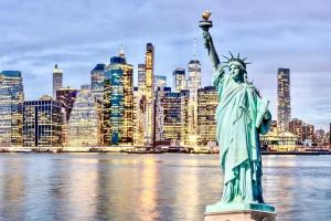 a statue of liberty with a city in the background at NYCRiverside 20MintsTime Square in West New York