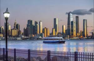 a boat on the water in front of a city at NYCRiverside 2BR Apt 20MintsTime Square in West New York
