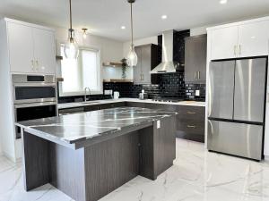 a large kitchen with a large island in the middle at Modern Luxurious Stay in Amherstburg