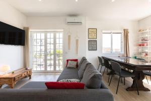 a living room with a gray couch and a table at Beach House 3 - Terrace sea sunset in Labruge