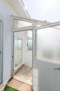 an open glass door in a room with windows at Beach House - Terrace sea sunset in Labruge +67 photos