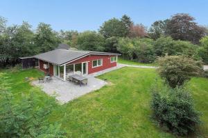 una cabaña roja con una mesa de picnic en un patio en K19088-Eskebjerg-Bjarnesvej-10, en Eskebjerg