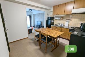 a kitchen with a wooden table and chairs in it at Nishi-Funabashi Residence in Funabashi