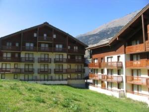 two buildings with balconies on them in a field at Appartement Lanslebourg 6 pers, 2 chambres, proche pistes - FR-1-508-309 in Val Cenis