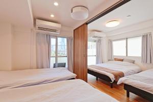 due letti in una stanza con due finestre di V Close to Shinjuku Kabukicho Korean Town FrWIFI B a Tokyo Altre 11 foto