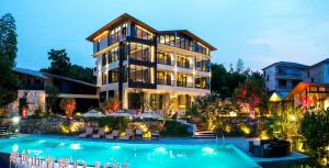 um grande edifício com uma piscina na frente em Zhangjiajie YOLO RELIAN Mt and River Collection-Riverside hotel with sunrise,sunset views, ticket service for attractions, afternoon tea,coffee, and laundry service em Zhangjiajie