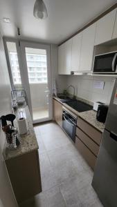 a kitchen with white cabinets and a counter top at Departamento 2D2B Full Equipado a Pasos del Mar in Coquimbo