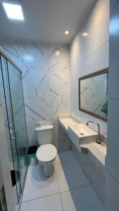 a white bathroom with a toilet and a sink at CASA COP 30 - Conjunto Marex - A poucos metros do Hangar e do Aeroporto de Belém in Belém