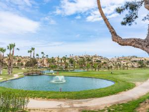a fountain in a pond in a park with palm trees at Family Villa with Valley Views in Rojales