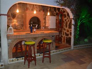 an outdoor kitchen with a counter and stools in a fake island at Family Villa with Valley Views in Rojales