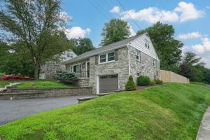 ein Steinhaus mit einer Garage in einem Hof in der Unterkunft Walnut Street Retreat with Hot Tub, 3 Bedrooms in Ephrata