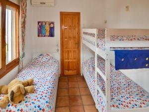 a bedroom with two bunk beds and a teddy bear at Family Villa with Valley Views in Rojales +32 photos