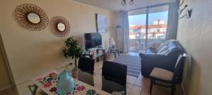 a living room with a couch and a table at Avenida del Mar Condominio Oceanic in La Serena