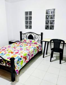 Un dormitorio con una cama y una mesa y sillas. en Casita entre árboles, casa de huéspedes céntrica y cómoda en San Fernando, Cali, en Cali