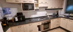 a kitchen with white cabinets and a black counter top at Avenida del Mar Condominio Oceanic in La Serena