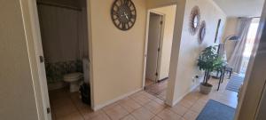 a bathroom with a toilet and a clock on the wall at Avenida del Mar Condominio Oceanic in La Serena +11 photos