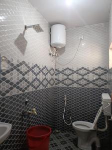 a bathroom with a toilet and a sink at Harvest Hill View Cottage in Ooty +6 photos