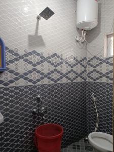 a bathroom with a toilet and a bucket in it at Harvest Hill View Cottage in Ooty