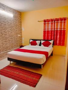 a bedroom with a large bed with red curtains at Harvest Hill View Cottage in Ooty