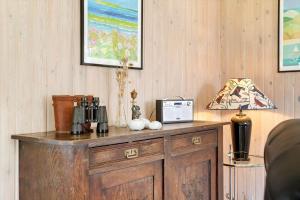 a wooden cabinet with a lamp on top of it at 20221-Samso-Violvej-8 in Tanderup