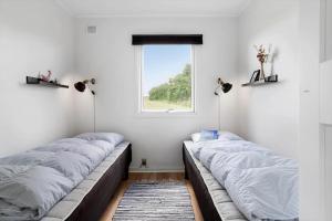 two beds in a room with a window at 20221-Samso-Violvej-8 in Tanderup