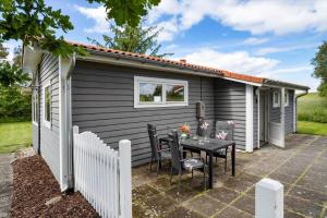 a small shed with a table and chairs on a patio at 20221-Samso-Violvej-8 in Tanderup