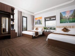 a hotel room with two beds and a television at Si Grand Ninh Binh Hotel in Ninh Binh