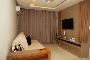a hotel room with a bed and a flat screen tv at Apê Cabo Frio - Praia do Forte in Cabo Frio