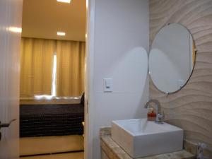 a bathroom with a sink and a mirror at Apê Cabo Frio - Praia do Forte in Cabo Frio +21 photos