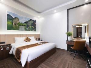 a hotel room with a large bed and a desk at Si Grand Ninh Binh Hotel in Ninh Binh +24 photos