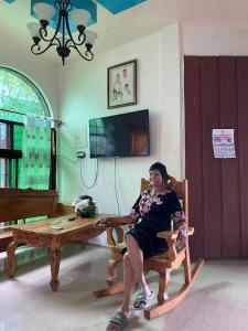 a woman sitting in a chair in a living room at Niknik in Cabadbaran
