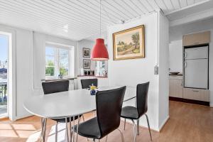a dining room with a white table and black chairs at 20203-Samso-Vrangstrup-5 in Tanderup